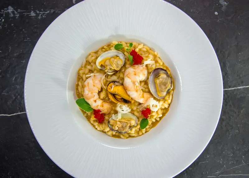 Seafood rice with prawns and clams in a white bowl