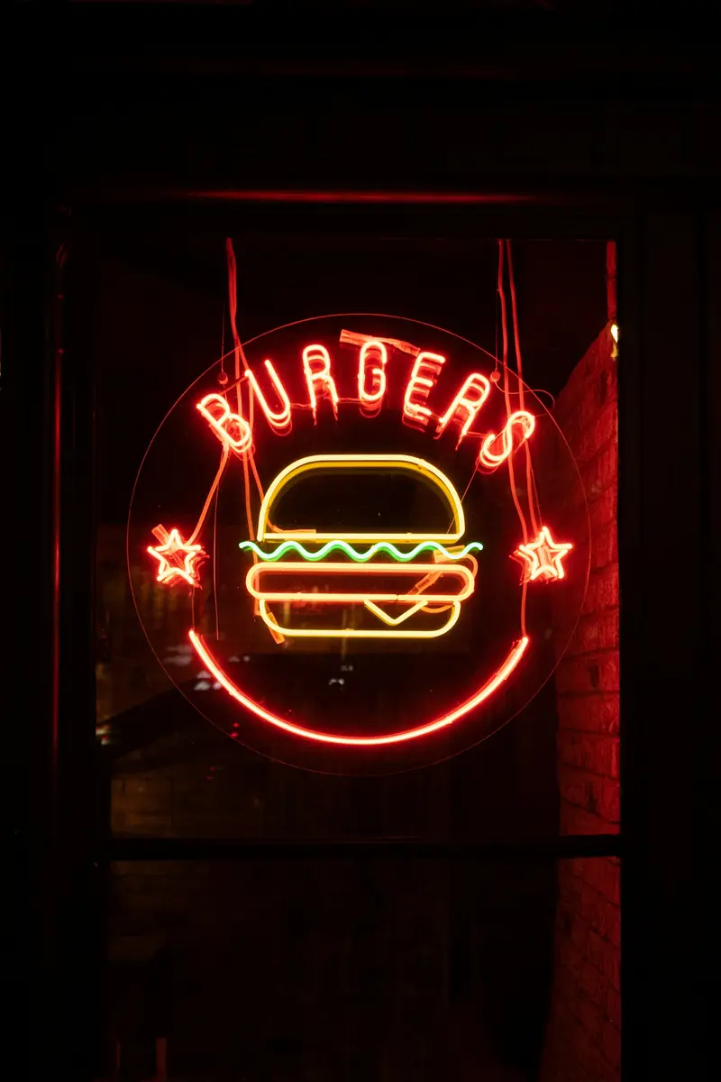 A red neon sign that says burgers